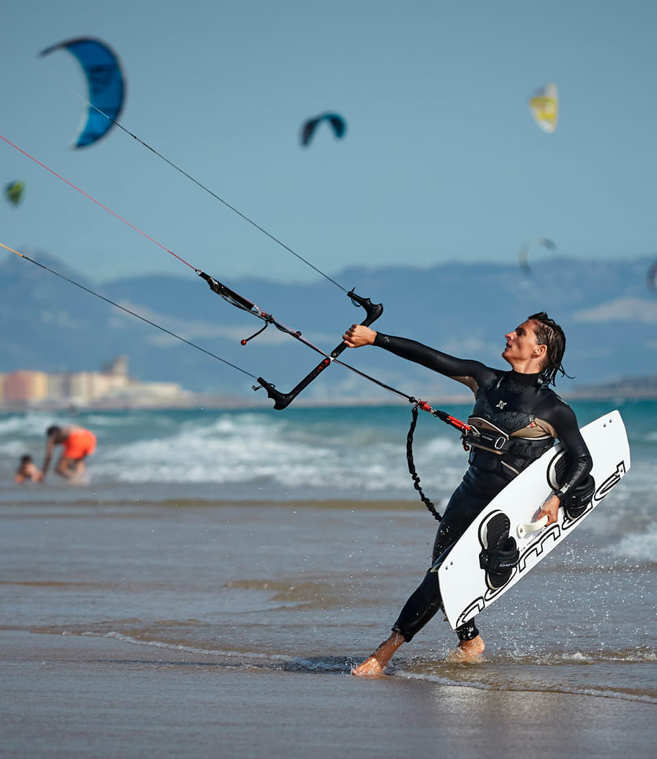 Kitesurfer coming out of the sea in Tarifa with the kite and the board in hand